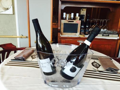 two bottles of wine in a glass on a table at Hotel Piero Della Francesca in Arezzo