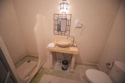 a bathroom with a sink and a toilet at Hotel Kasbah Ennakhile in Nkob