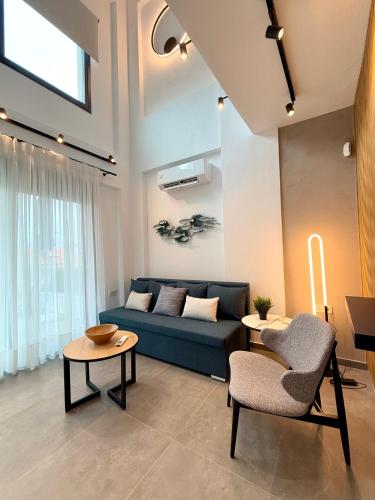 a living room with a blue couch and a table at Diamond A3 in Iraklitsa