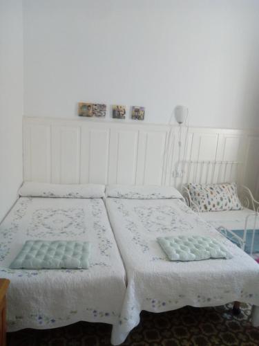 two beds in a room with white walls at Casa de Comedias in Almagro