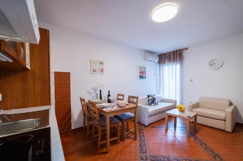 a kitchen and living room with a table and a couch at Lopar 516 in Lopar