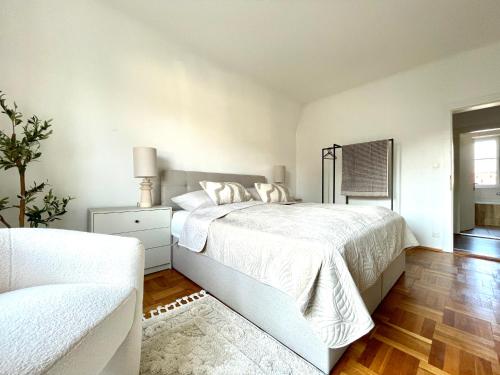 a white bedroom with a bed and a couch at Anne in Sankt Pölten