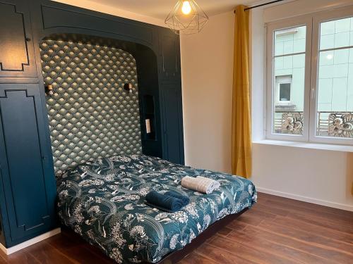 une chambre avec un lit avec une tête de lit et une fenêtre dans l'établissement L'élegant Belfortain, à Belfort