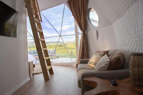 a woman laying on a couch in a room with a guitar at DomeHome in Waiotapu