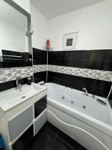 クラヨーヴァにあるApartament Brazdăの白い浴槽と洗面台のあるバスルーム