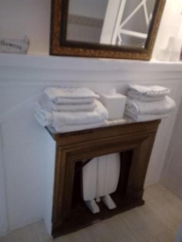 a bathroom with a table with towels and a mirror at Casa de Comedias in Almagro