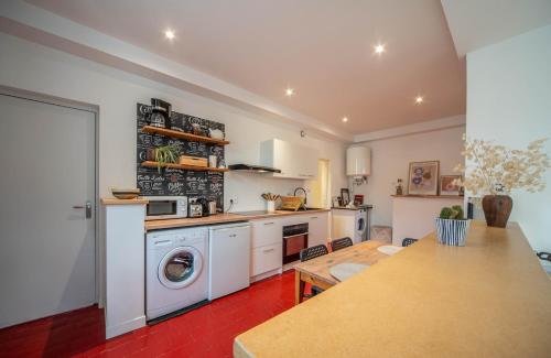 a kitchen with a washer and a washing machine at Le refuge citadin in Tournus