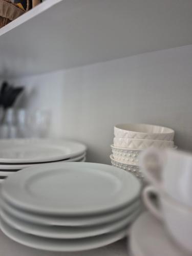 a pile of white plates and bowls on a table at Condomínio Residencial Serigy in Aracaju