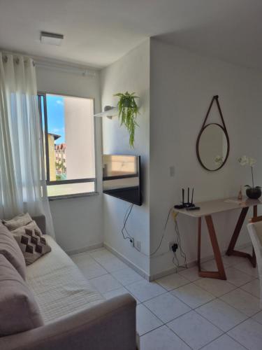 a living room with a couch and a table and a mirror at Condomínio Residencial Serigy in Aracaju