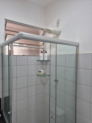 a bathroom with a shower with white tiles at Condomínio Residencial Serigy in Aracaju
