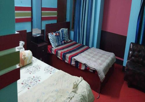 two beds in a room with colorful walls at The Hotel Golden Star in Khulna