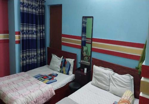a bedroom with two beds and a mirror at The Hotel Golden Star in Khulna