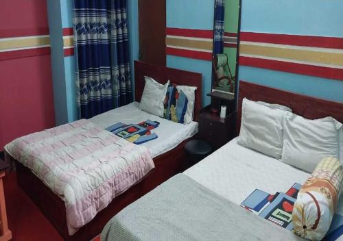 two beds in a room with two at The Hotel Golden Star in Khulna