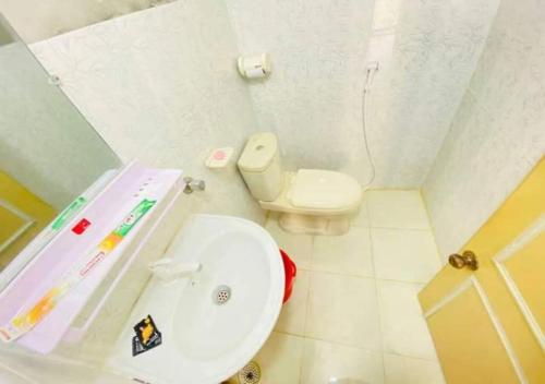 a white bathroom with a toilet and a sink at The Hotel Golden Star in Khulna