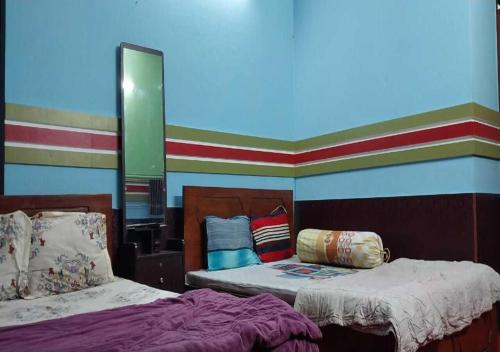 a bedroom with two beds and a mirror at The Hotel Golden Star in Khulna