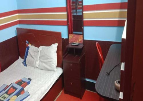 a small room with a bed and a chair at The Hotel Golden Star in Khulna