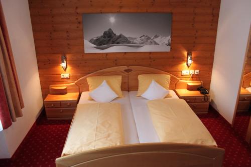 a bedroom with a large bed with two pillows at Hotel Garni Dorfblick in Sankt Anton am Arlberg
