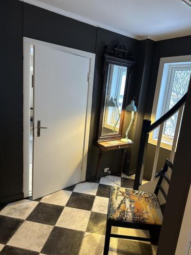 a room with a door and a chair and a mirror at Comfortable house in Gryllefjord in Senja
