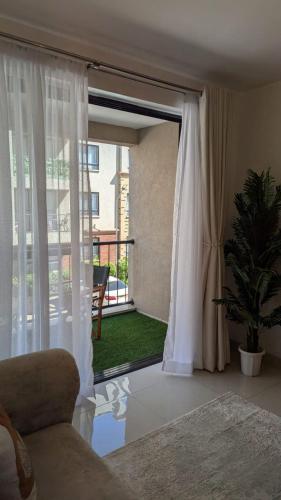 a living room with a sliding glass door to a patio at Sulwe homes 5 MINUTES FROM JOMO KENYATTA INTERNATIONAL AIRPORT in Nairobi