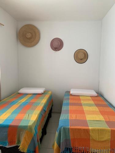 two beds in a room with colorful blankets at Casa inteira próximo ao Cumbuco e Fortaleza in Caucaia