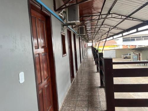 an empty corridor of a building with wooden doors at Hotel Panachê in Boa Vista