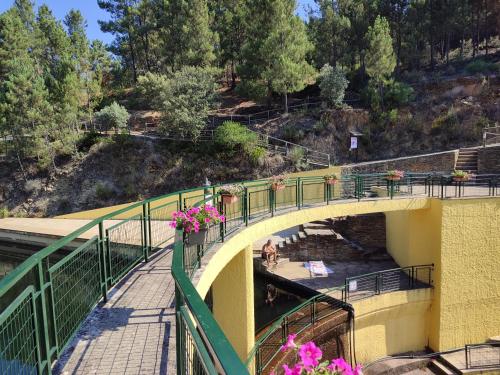 a bridge over a river with flowers on it at Casa Iris Cunqueiros in Sobreira Formosa