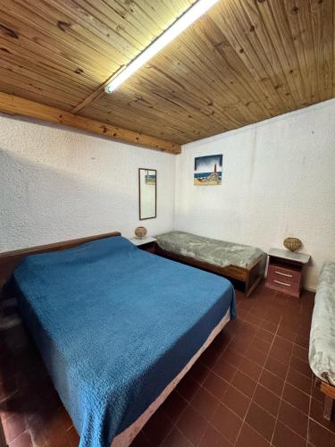 a bedroom with a blue bed and a couch at Angelita sobre playa in Aguas Dulces