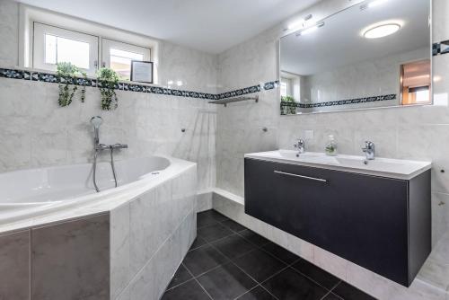 a white bathroom with a tub and a sink at Spacious 120m2 Water Villa With Sauna Near Amsterdam in Aalsmeer