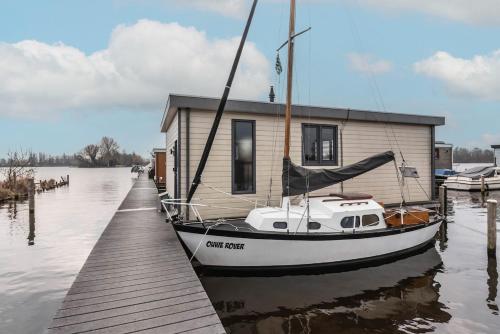 a small boat is docked at a dock at Spacious 120m2 Water Villa With Sauna Near Amsterdam in Aalsmeer