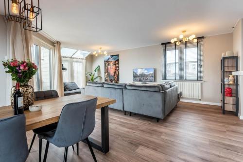 a living room with a table and a couch at Spacious 120m2 Water Villa With Sauna Near Amsterdam in Aalsmeer