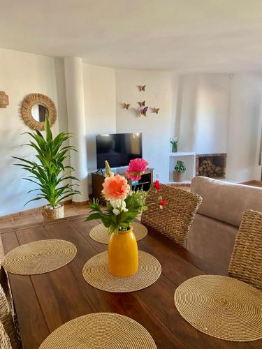 a living room with a table with flowers in a yellow vase at Apartamento La casa Verde in Punta Prima