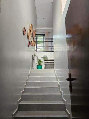 a staircase in a house with white walls at Ripple House in Namulanda