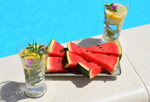 a plate of watermelon on a table with two glasses at Pansion Savinac in Takovo