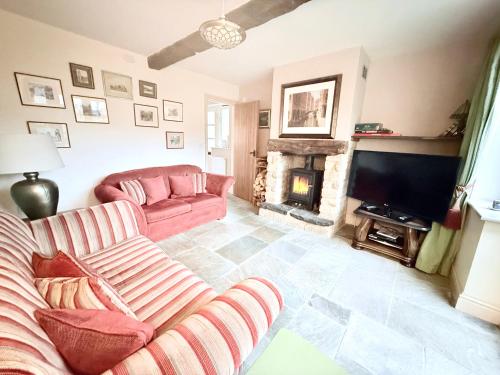 a living room with a couch and a fireplace at Misty View - 2 Bed Cottage in Winchcombe in Winchcombe
