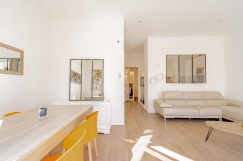 una sala de estar con un sofá y una mesa en Bel appartement avec balcon centre ville, en Cannes