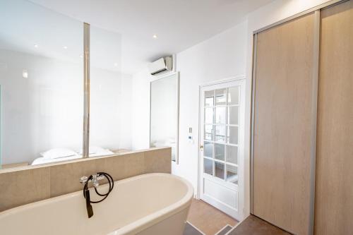 Una bañera blanca en un baño con ventana. en Bel appartement avec balcon centre ville, en Cannes
