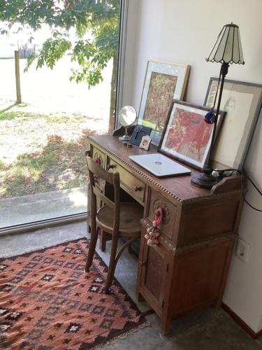 an old desk with a lamp and a picture on it at Casa de artista in Colonia del Sacramento