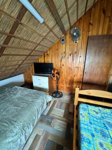 a bedroom with two beds and a desk and a fan at Angelita in Aguas Dulces