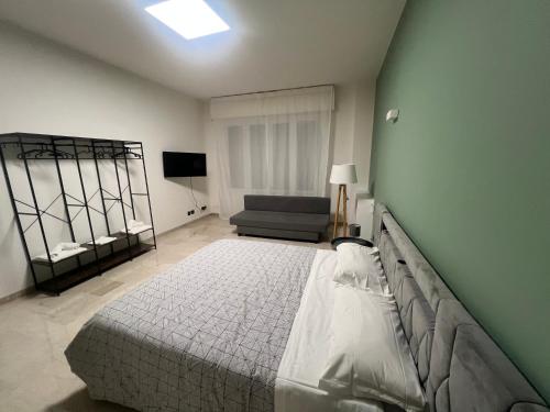 une chambre avec un grand lit et une chaise dans l'établissement ManaroomsMarconi, à Bologne