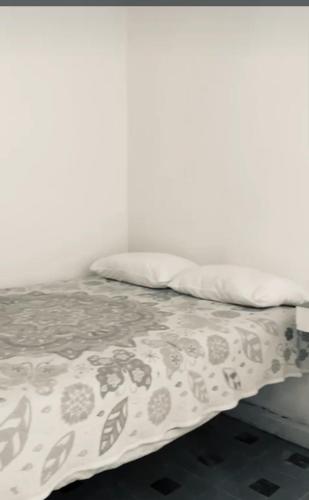 Una cama con una manta y almohadas encima en Casa los abuelos, en San Luis Potosí