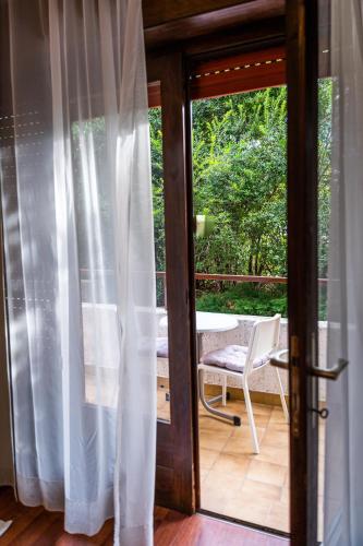an open door to a patio with a table and a chair at Lopar 516 in Lopar
