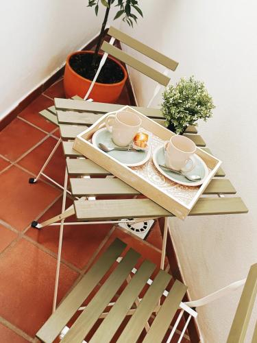 einen Holztisch mit zwei Tassen und Untertassen darauf in der Unterkunft Évoca Home in Córdoba
