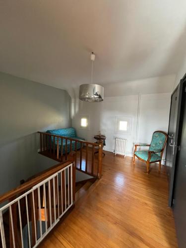 un salon vide avec un escalier et des chaises dans l'établissement Maison au bord du lac, à Saint-Étienne-Cantalès