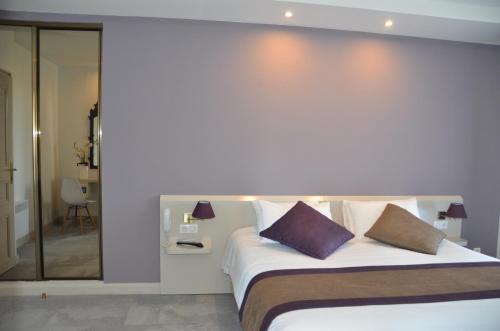 a bedroom with a large bed with two pillows at Hotel et Spa Les Cleunes Oléron in Saint-Trojan-les-Bains