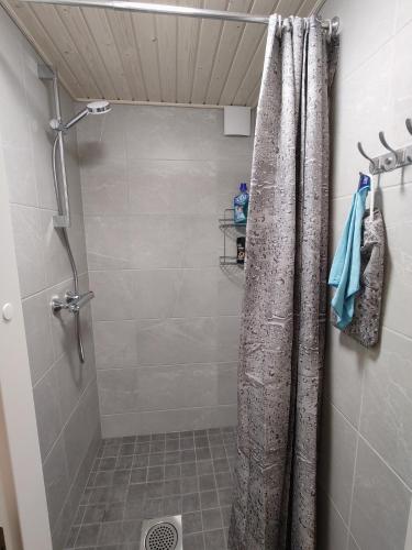 a shower with a shower curtain in a bathroom at Peltokankaan tila in Ylivieska