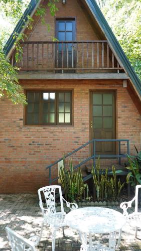 a patio with a table and chairs in front of a house at Cabañas Nueva Alborada in Nueva Alborada