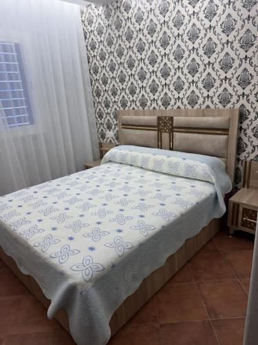 a bed in a bedroom with a wall at Marinasmir Jawhara in Fnidek