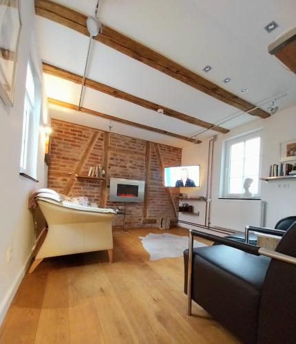 a living room with a couch and a table and a tv at Hof Eckens - Ferienhaushaus Marie in Wildeck Bosserode in Wildeck