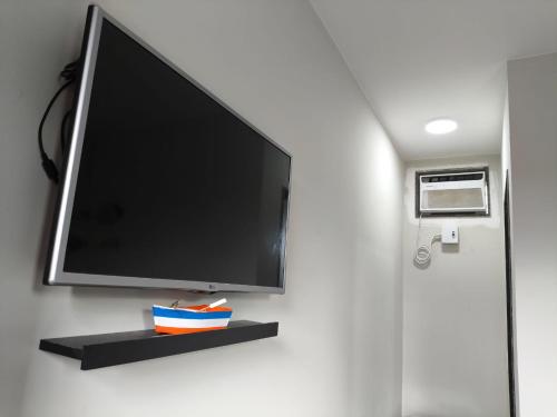 a flat screen tv hanging on a wall at Suíte Varanda Vist Mar Sonho do Pontal Arraial do Cabo in Arraial do Cabo