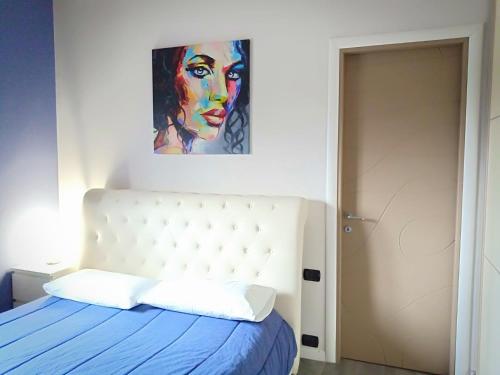 a bedroom with a bed with a painting on the wall at Le Stanze di Marco in Monza
